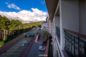 einen Balkon eines Gebäudes mit Autos auf einem Parkplatz in der Unterkunft Vista Azul Hotel in Pedra Azul