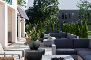 une terrasse avec des canapés, des tables et des plantes dans l'établissement Elwood Hotel & Suites, à Lexington