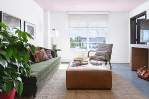 a living room with a couch and a chair at Elwood Hotel & Suites in Lexington