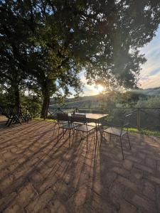 uma mesa de piquenique e cadeiras sentadas debaixo de uma árvore em Agriturismo I Getsemani em Bevagna