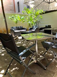 巴勒摩的住宿－LE PORTE DI PALERMO，玻璃桌,带两把椅子,桌子和玻璃