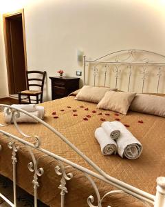 Un dormitorio con una cama con toallas y rosas. en LE PORTE DI PALERMO, en Palermo
