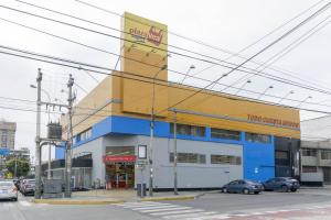 a yellow and blue building with cars parked in a parking lot at Corpac Apartment in Lima