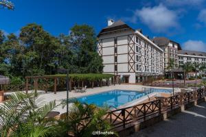 Vista Azul Hotel في بيدرا أزول: فندق فيه مسبح امام مبنى
