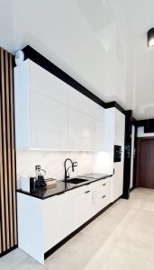 una cocina con armarios blancos y fregadero en Apartamenty Aquarius Gold Boszkowo en Boszkowo