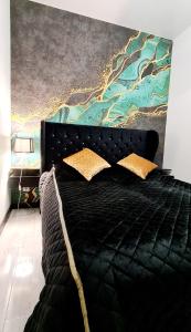 博斯科沃的住宿－Apartamenty Aquarius Gold Boszkowo，卧室配有一张黑色床,墙上挂有绘画作品