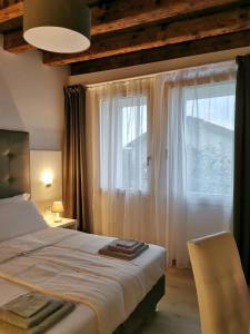 a bedroom with a bed and a large window at Casa BORRIERO Farmhouse in Sospirolo