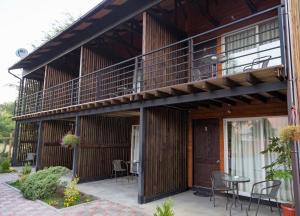 a building with a balcony and tables and chairs at Verdevida Apart Hotel in Pucón