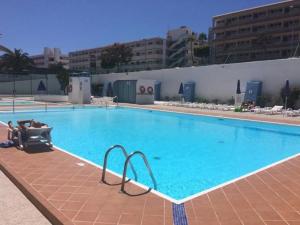 une grande piscine bleue dans un bâtiment dans l'établissement Playa del Inglés 5 min walk from Yumbo! 304, à Maspalomas