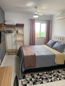 een slaapkamer met een bed en een raam bij Apartamento no Golden Lake - pé na areia, agua de côco e cervejinha in Arraial do Cabo