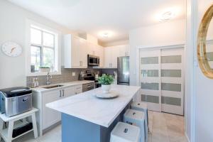 Una cocina con gabinetes blancos y una encimera blanca. en Panoramic Views from this gorgeous 2 Bed Property - Village Location, en Whistler
