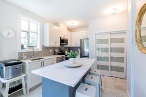 a kitchen with white cabinets and a white counter top at Panoramic Views from this gorgeous 2 Bed Property - Village Location in Whistler