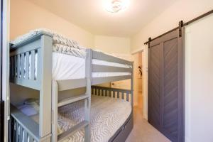 a bunk room with two bunk beds and a door at Panoramic Views from this gorgeous 2 Bed Property - Village Location in Whistler