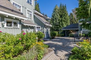 a walkway in front of a house with flowers at Panoramic Views from this gorgeous 2 Bed Property - Village Location in Whistler