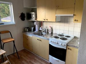 a kitchen with a stove and a sink at Mäntyharju keskus, yksityishuoneita, keittiöllä in Mäntyharju