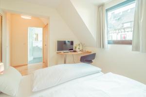 a bedroom with a bed and a desk with a computer at Hotel Restaurant zur Sonne St. Peter in Sankt Peter