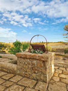 Una caja de piedra con flores encima. en Carrua, en Marzamemi