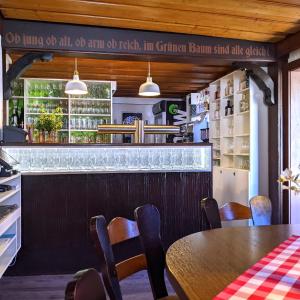 a dining room with a table and a bar at Boutique-Hotel Zum Grünen Baum in Alzenau