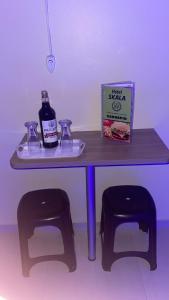 einen Tisch mit einer Flasche Alkohol und zwei Hockern in der Unterkunft HOTEL SKALA in São Paulo
