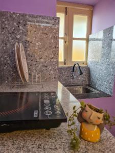 2 fotos de una cocina con fregadero y encimera en Dula HomeStay, en Guwahati