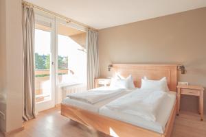um quarto com uma cama grande e uma janela grande em Hotel Restaurant zur Sonne St. Peter em Sankt Peter