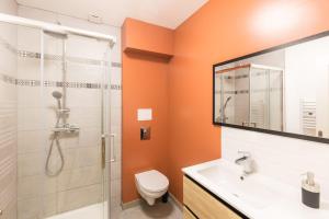 an orange bathroom with a toilet and a shower at Désirée Logement Cosy et Charmant 1 er étage in Reims