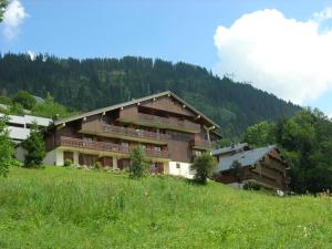 un gran edificio en la cima de una colina con césped en Studio Châtel, 1 pièce, 4 personnes - FR-1-198-192 en Châtel