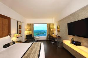 ein Hotelzimmer mit einem Bett und einem Flachbild-TV in der Unterkunft Fortune Select SG Highway, Ahmedabad - Member ITC's Hotel Group in Ahmedabad