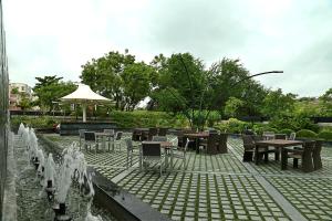 un patio con mesas, sillas y una fuente. en Fortune Select SG Highway, Ahmedabad - Member ITC's Hotel Group en Ahmedabad