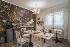 a dining room with a table and chairs and a wall mural at B&B L'Ulivo Fiumicino in Fiumicino