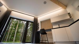 a kitchen with a large window and a stool at Serenity House & Sauna on the Coast of Baltic Sea in Lapmežciems