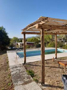 een houten pergola naast een zwembad bij La Maru in Villa Giardino