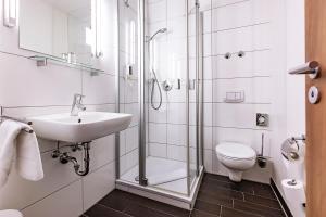a bathroom with a shower and a sink and a toilet at Hotel am Jakobsmarkt in Nuremberg