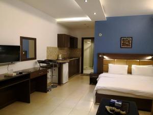 une chambre d'hôtel avec un lit et une cuisine dans l'établissement 7 Days Hotel, à Umm Uthainah
