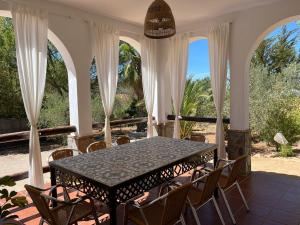 a table and chairs on a patio with a view of the ocean at Casa Almendro Rural in Guadalcanal