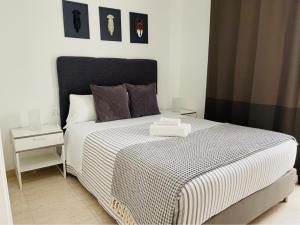 a bedroom with a bed with a black and white comforter at MC Apartaments in Puerto del Rosario