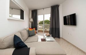 a living room with a couch and a tv at MC Apartments in Puerto del Rosario