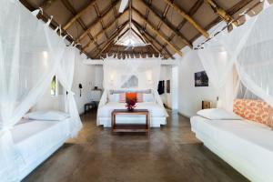 1 dormitorio con 2 camas blancas y mesa en Aite Eco Resort en Palomino