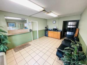 a waiting room with a couch and a kitchen at Rogers Inn in Rogers