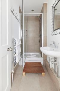 a bathroom with a shower and a sink and a tub at The Woolwich Retreat - Enticing 5BDR House with Parking in Woolwich