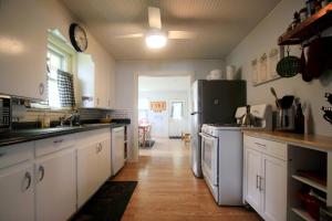 eine Küche mit weißen Schränken und einem schwarzen Kühlschrank in der Unterkunft 3314 Highland Ave, home in Ashville