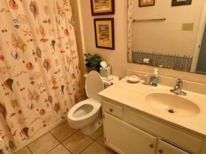 een badkamer met een wastafel, een toilet en een douchegordijn bij Surfside By The Sea Ii 103 Condo in Myrtle Beach