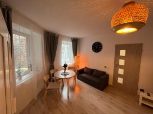 sala de estar con mesa y sofá en London Apartments - Free parking en Katowice