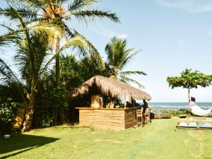 bar aiki na praia com palmeiras e o oceano em Casa do Amor Caraíva em Caraíva