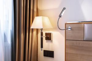 a lamp on a wall next to a curtain at Hotel am Jakobsmarkt in Nuremberg