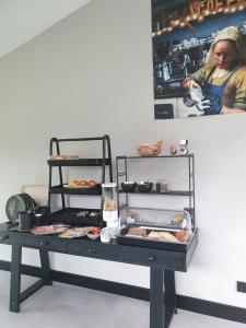 uma mesa com uma prateleira com comida em Hippe Schuur em Tietjerk