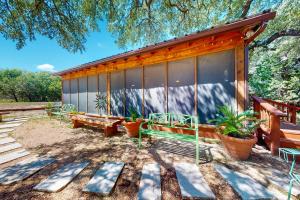 una casa con bancos y plantas delante de ella en Cabin-Style Book House & Writing Barn, en Austin