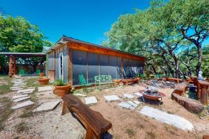 a patio with benches and a building with trees at Cabin-Style Book House & Writing Barn in Austin