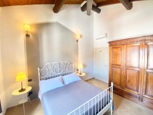 1 dormitorio con cama blanca y armario de madera en B&B STAZIONE DON CAMILLO, en Brescello