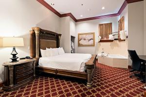 a large bedroom with a bed and a bath tub at Chateau Avalon in Kansas City